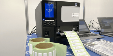 自動認識総合展名古屋の展示ブースにて、ラベルプリンタで印字が可能な金属対応RFIDタグが置かれている様子。