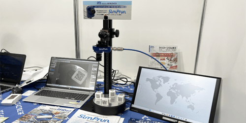 自動認識総合展名古屋の展示ブースにて、テーブルの上にシンプルなスマートカメラ「SimPrun」が置いてある様子。
