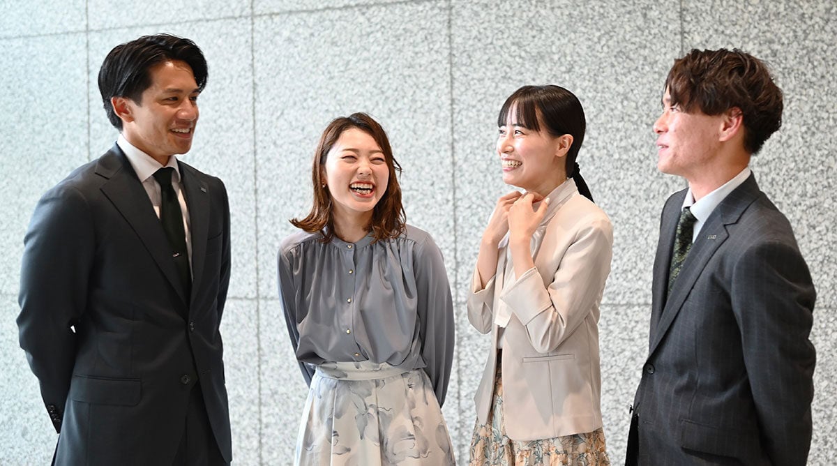笑顔で談笑する4人の社員